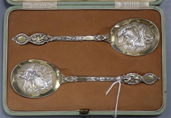 A cased pair of Edwardian ornate parcel gilt silver serving spoons, Robert Stebbings, London 1902, 19.5cm.